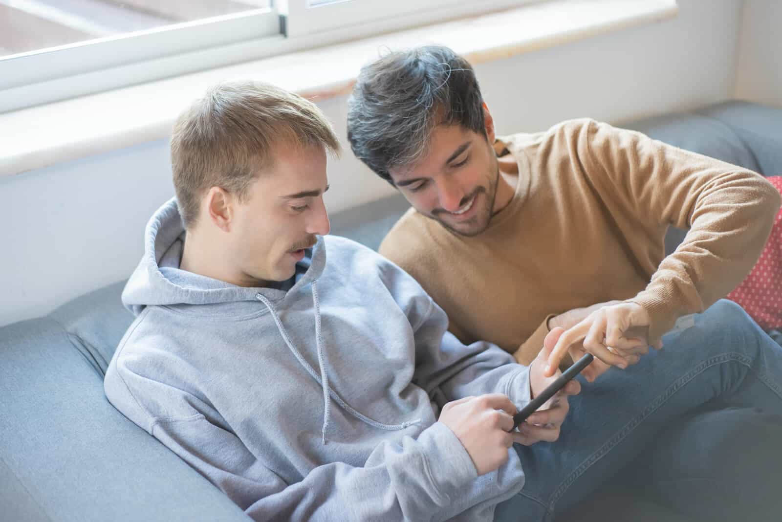Gay male couple checking a cell phone